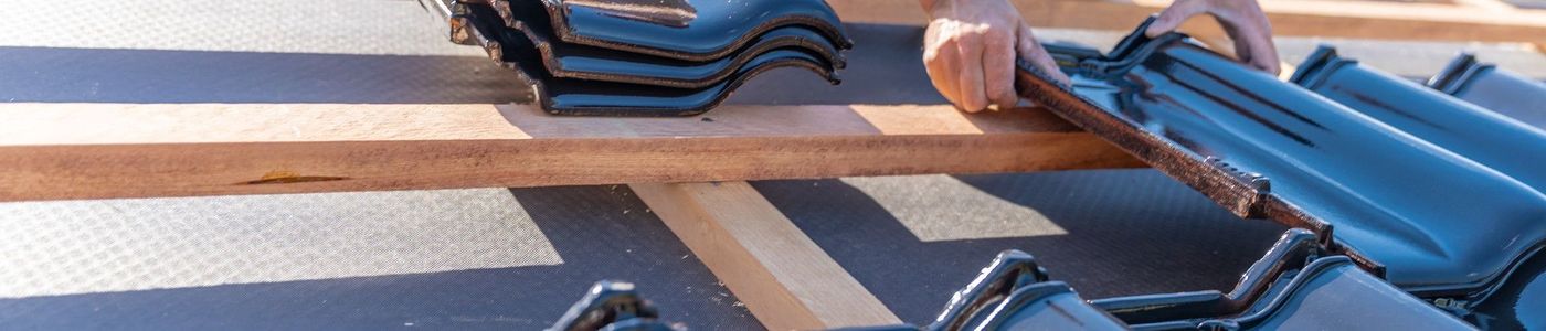 Szakember dolgozik modern cserepes tetőn, megbízható tetőfedő szolgáltatás országosan.